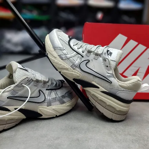 کتونی زنانه نایکی وی ۲ کی ران (Nike V2K Run) - رویه توری سفید و استخوانی با جزئیات نقره‌ای و زیره لژدار طبی vintage | مستر کوالیتی
