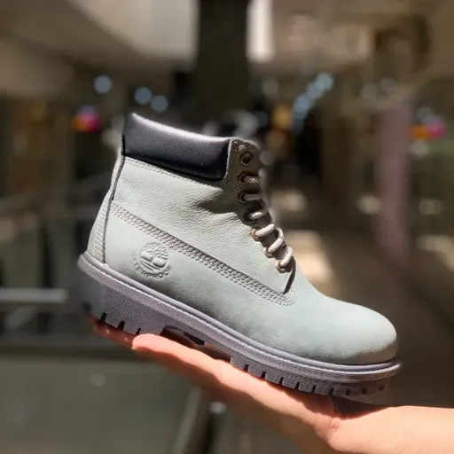 نیم‌بوت تیمبرلند (Timberland) زنانه - چرم اشبالت طوسی روشن با لبه بالایی مشکی، دوخت دور و زیره عاج‌دار | مستر کوالیتی